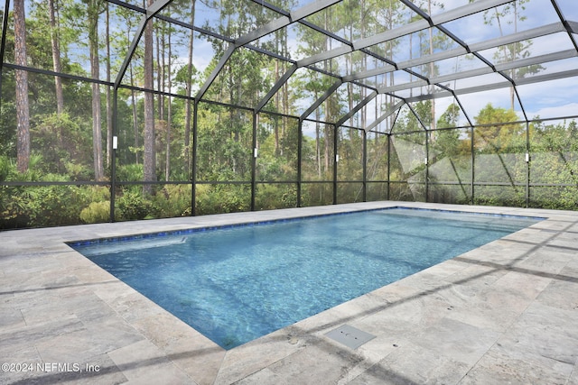 view of swimming pool featuring a lanai and a patio area