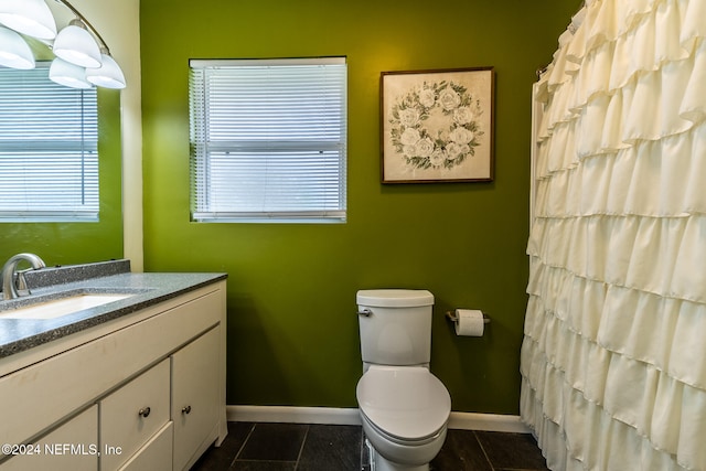 bathroom featuring tile patterned floors, vanity, a healthy amount of sunlight, and toilet