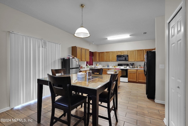 dining area featuring a textured ceiling and light hardwood / wood-style flooring