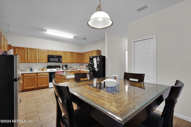 dining room featuring a textured ceiling and light hardwood / wood-style floors