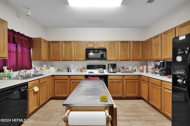 kitchen with light hardwood / wood-style floors, a textured ceiling, sink, and black appliances