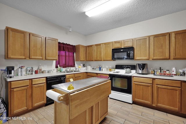 kitchen featuring a textured ceiling, sink, and black appliances