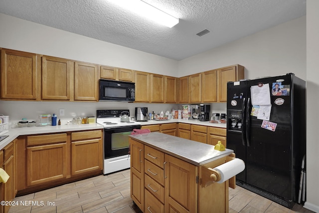 kitchen with a textured ceiling and black appliances