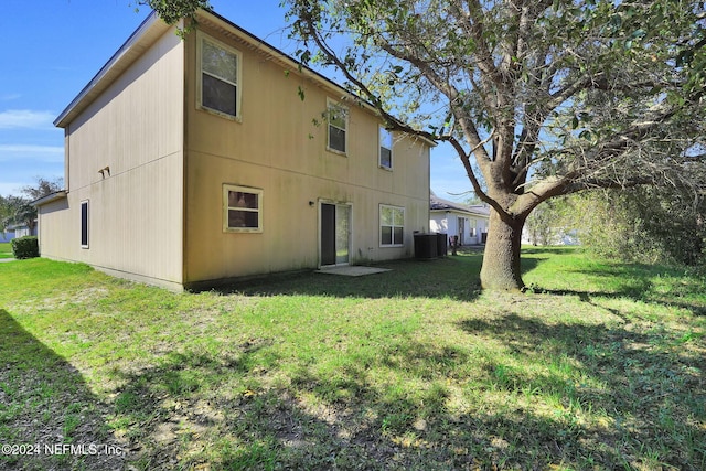 back of house featuring central AC and a lawn