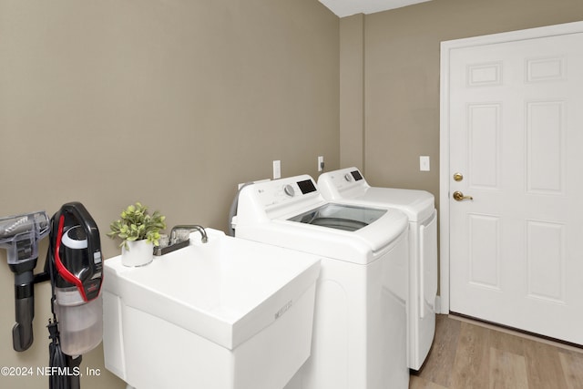 washroom with sink, light wood-type flooring, and washer and clothes dryer