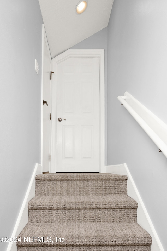 staircase with vaulted ceiling