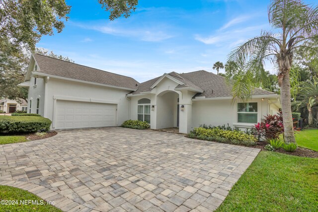 ranch-style home with a garage and a front yard