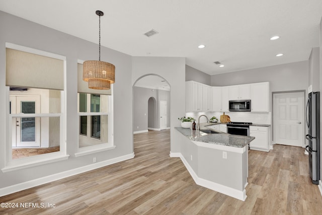 kitchen with kitchen peninsula, white cabinetry, pendant lighting, and appliances with stainless steel finishes