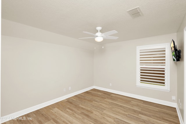 spare room featuring hardwood / wood-style floors, ceiling fan, and a textured ceiling