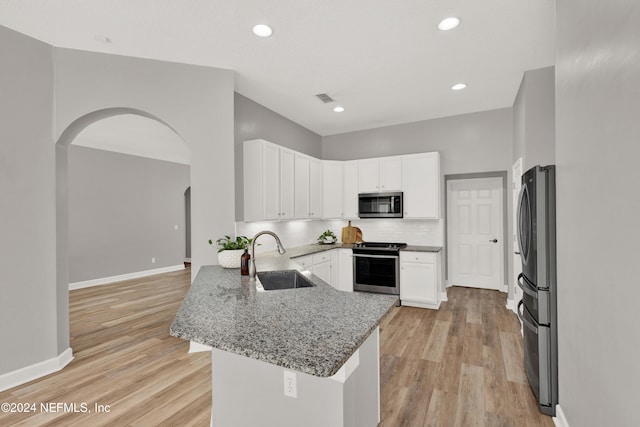 kitchen with white cabinetry, kitchen peninsula, stainless steel appliances, and sink