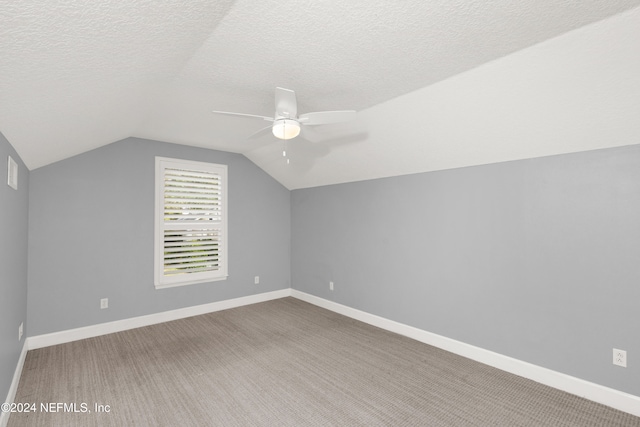 bonus room featuring carpet, vaulted ceiling, and a textured ceiling