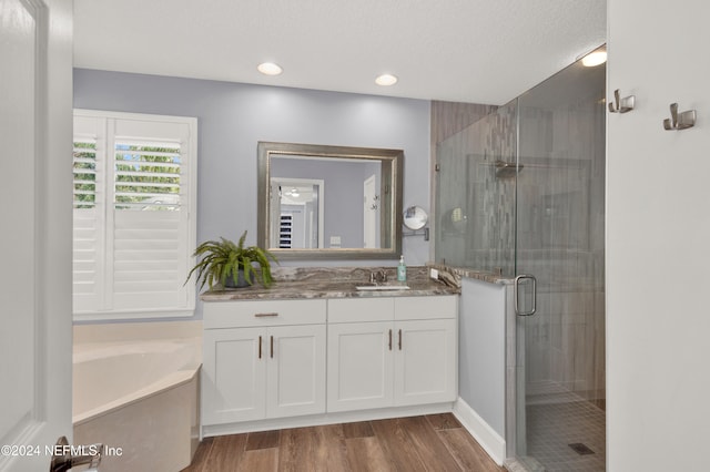 bathroom featuring vanity, shower with separate bathtub, wood-type flooring, and a textured ceiling