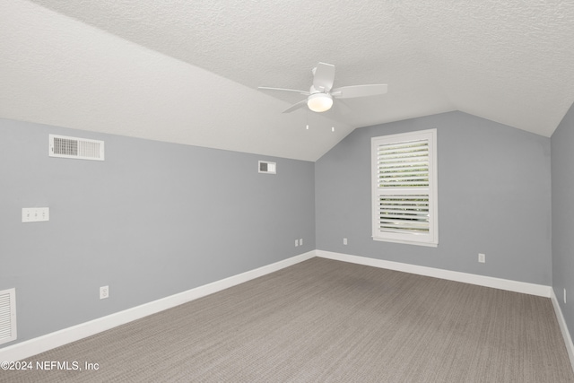 additional living space with ceiling fan, a textured ceiling, lofted ceiling, and carpet floors