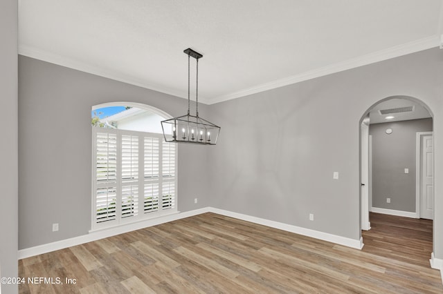 unfurnished dining area with light wood-type flooring, a notable chandelier, and ornamental molding