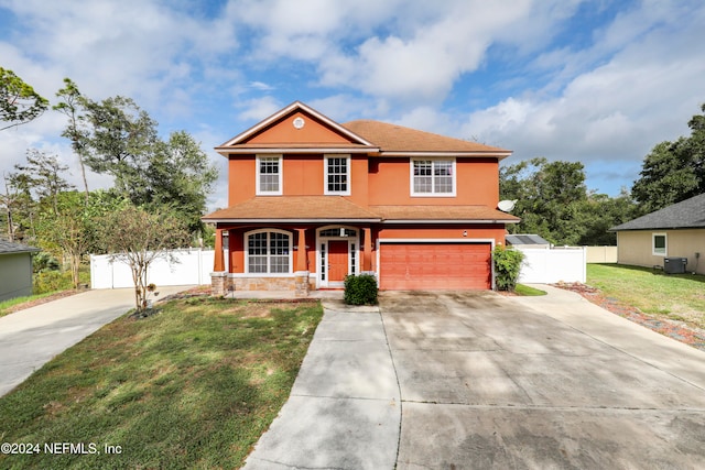 front of property with a garage, cooling unit, and a front yard