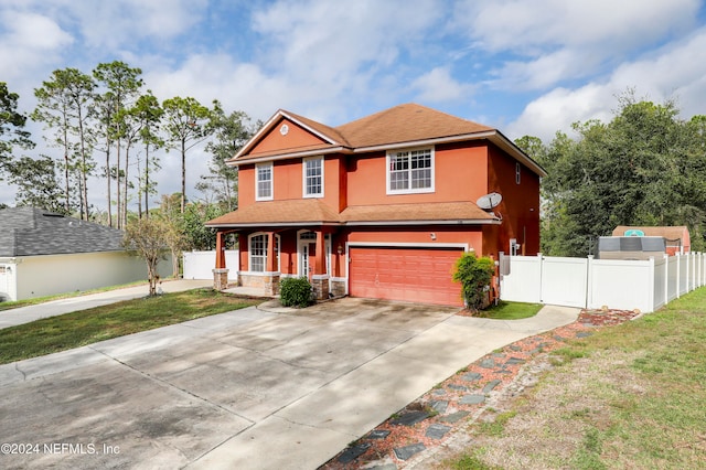 view of front of property featuring a garage, a front yard, and a porch