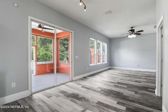 empty room with hardwood / wood-style floors, ceiling fan, and a textured ceiling