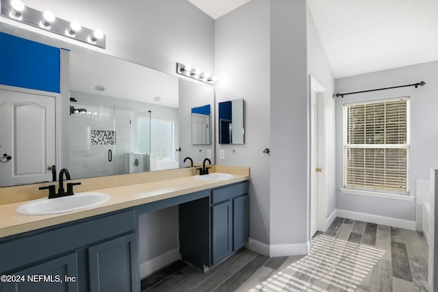 bathroom featuring hardwood / wood-style flooring, vanity, an enclosed shower, and lofted ceiling