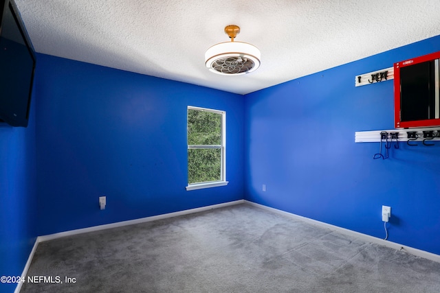 carpeted empty room with a textured ceiling