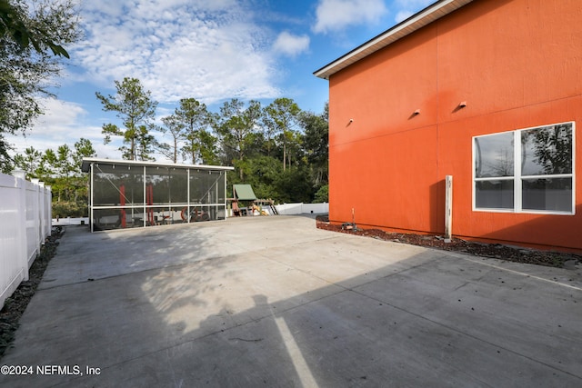 view of side of home featuring a patio area and a sunroom