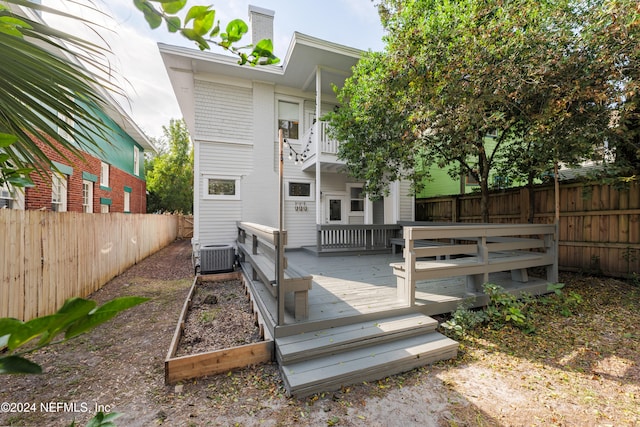 back of property with a balcony, central AC unit, and a wooden deck