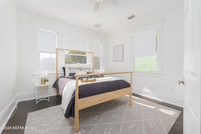 bedroom with ceiling fan, dark hardwood / wood-style flooring, and ornamental molding