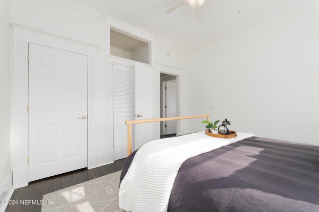 bedroom with ceiling fan, dark hardwood / wood-style flooring, and ornamental molding