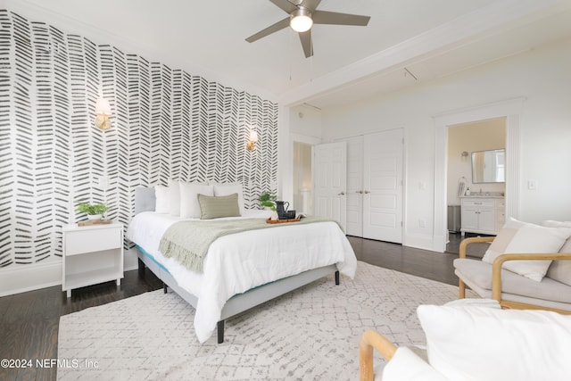 bedroom with ceiling fan, dark hardwood / wood-style flooring, and connected bathroom