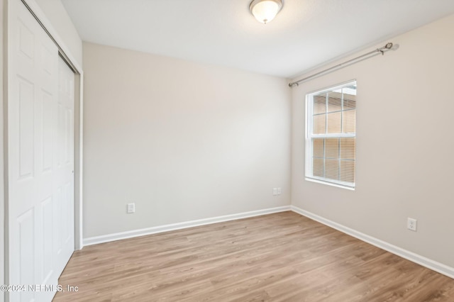 unfurnished bedroom with light hardwood / wood-style floors and a closet