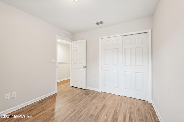 unfurnished bedroom featuring a closet and light hardwood / wood-style flooring