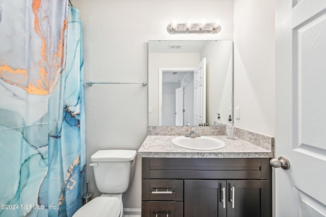 bathroom featuring vanity, toilet, and walk in shower