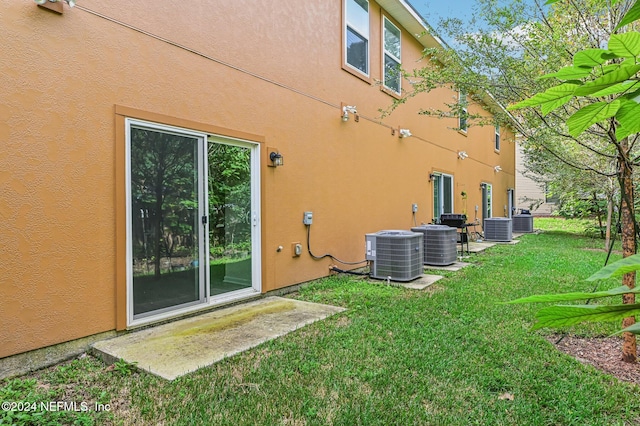 exterior space featuring a patio area, cooling unit, outdoor lounge area, and a yard