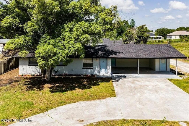 view of front of home with a carport and a front lawn