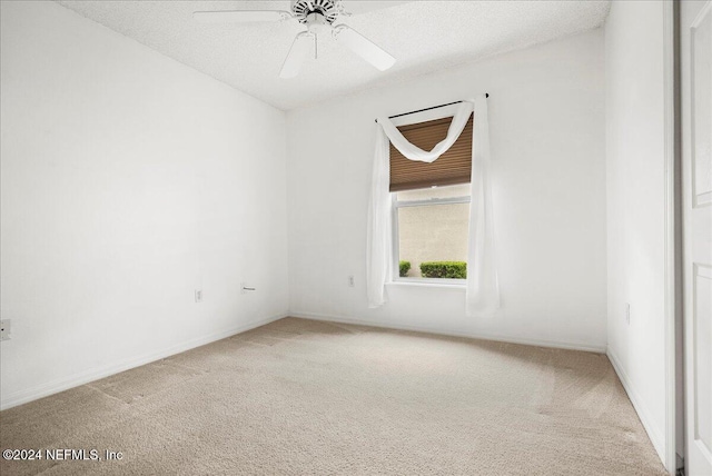 carpeted empty room with a textured ceiling and ceiling fan