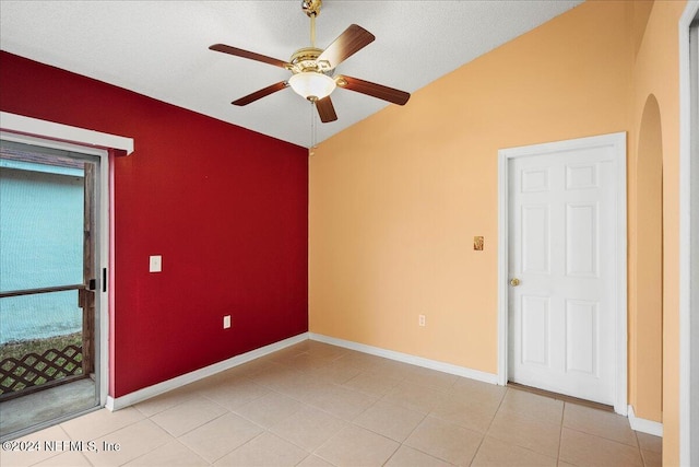 tiled empty room featuring ceiling fan, a textured ceiling, and lofted ceiling