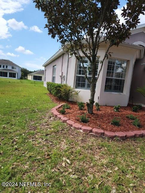 view of home's exterior with a lawn and stucco siding