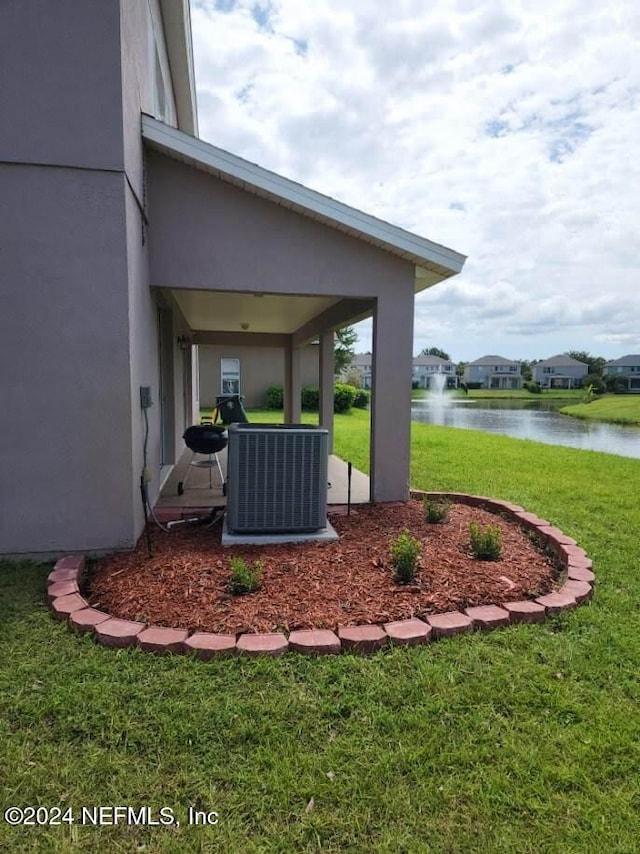 view of yard with a water view and central air condition unit