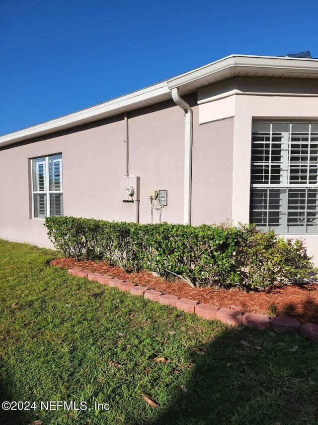 view of property exterior featuring a lawn and stucco siding