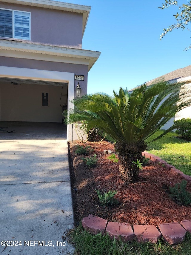 exterior space featuring concrete driveway and stucco siding