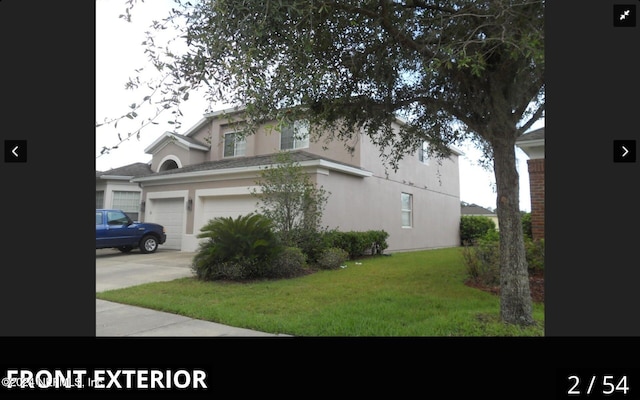 view of side of property featuring a garage and a lawn