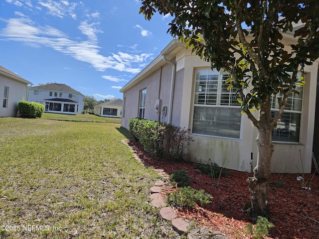 view of side of home featuring a yard and stucco siding