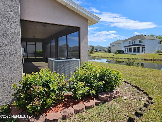 view of yard featuring a water view and central air condition unit