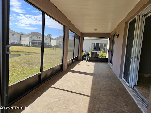 unfurnished sunroom featuring a wealth of natural light and a residential view