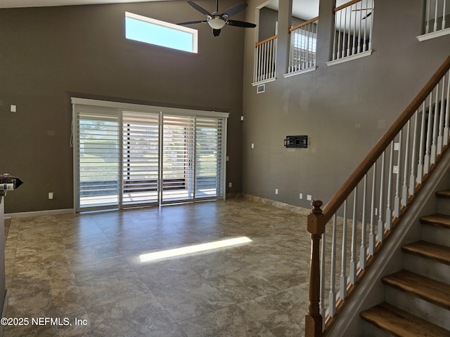 unfurnished living room with a healthy amount of sunlight, ceiling fan, and baseboards