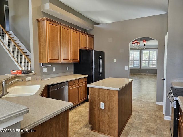 kitchen with arched walkways, a center island, stainless steel appliances, light countertops, and a sink