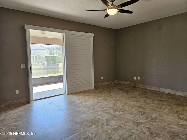 empty room with ceiling fan and a textured ceiling