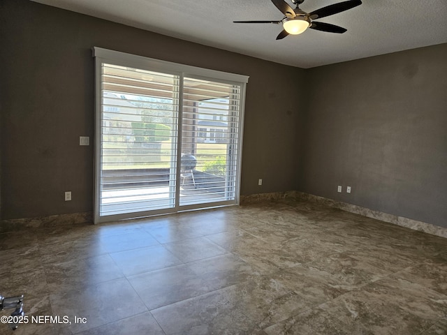 unfurnished room featuring a ceiling fan and a textured ceiling