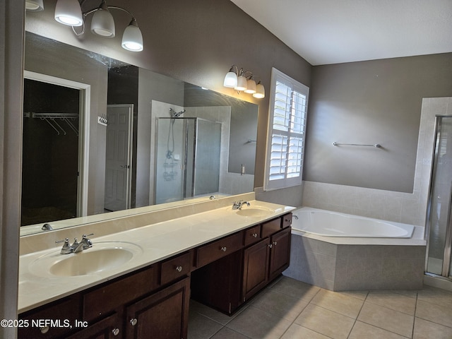 bathroom featuring a spacious closet, a stall shower, and a sink