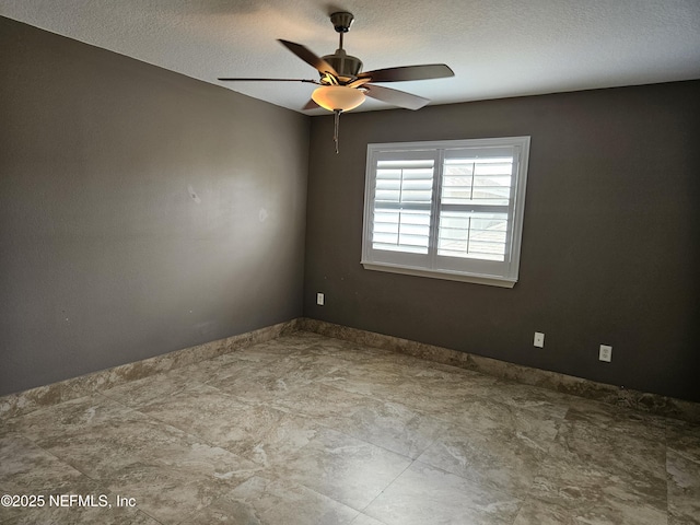 unfurnished room featuring ceiling fan and a textured ceiling