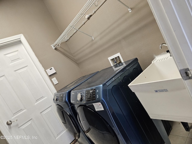 washroom with washer and dryer, laundry area, tile patterned flooring, and a sink